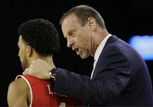 Utah head coach Larry Krystkowiak talks to Isaiah Wright during the first half of a college basketball regional semifinal game against Duke in the NCAA Tournament Friday, March 27, 2015, in Houston. (AP Photo/David J. Phillip)