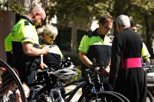Leah Hogsten | The Salt Lake Tribune
Salt Lake City bicycle patrolman Cole Brock and other members of the bike patrol receive a blessing. Cyclists filled the block between 100 and 200 South in downtown Salt Lake City Saturday, September 28, 2013 during the "8th Annual Blessing of the Bikes" at the Cathedral Church of St. Mark. The event was aimed at raising awareness of bicycle safety for anyone on on or two wheels including scooters, bicycles, motorcycles, unicycles, tricycles,