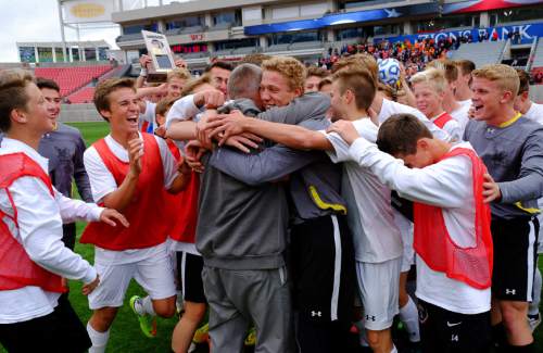 Francisco Kjolseth  |  The Salt Lake Tribune 
Alta coach Lee Mitchell is embraced by his team as they celebrate their 2-1 win over Brighton following the 5A boys' soccer championship game at Rio Tinto Stadium on Thursday, May 21, 2015.