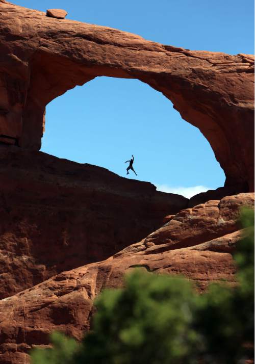 Francisco Kjolseth  |  The Salt Lake Tribune
A visitor to Arches National Park jumps for the camera snapped by a friend on the other side while visiting Skyline Arch in late May.