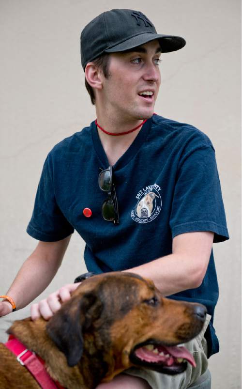 Lennie Mahler  |  The Salt Lake Tribune
Mitch Behrmann, a volunteer with Salt Lake County Animal Services, sits with Nala, a 2-year-old Rottweiler mix, during a walk on Friday. A math student at the University of Utah, Behrmann said he loves to spend time at the shelter with shy dogs, to watch them progress and become more comfortable with people and even learn tricks. Behrmann said people have a misconception that shelter dogs are broken, when in reality they are just like other dogs.