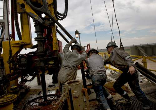 (Tribune file photo)

Floorhands work on the drilling platform of the 68 Pioneer Rig, a telescoping rig, in Newfield Exploration Company's oil fields in the Central Basin near Roosevelt, Utah, on August 9, 2012.