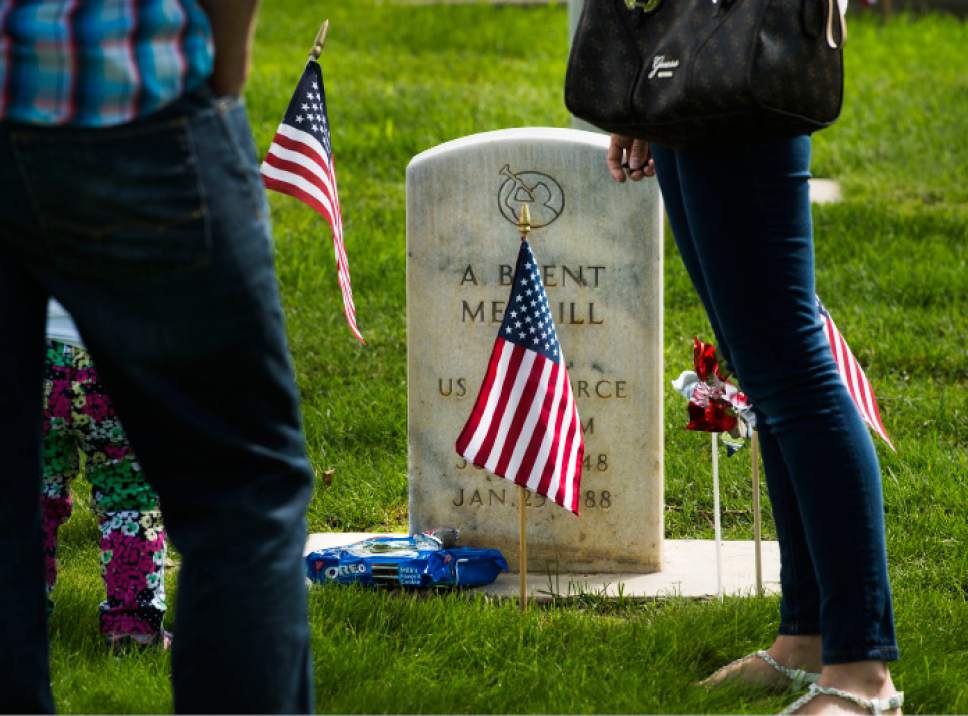 Steve Griffin  |  The Salt Lake Tribune
Becky Clark, right, stands with her husband, Jeff, and their children Brinley and Mason as they eat Oreo cookies at the grave of her father, Air Force Maj. A. Brent Merrill, as Fort Douglas hosts its annual Memorial Day observance at the cemetery in Salt Lake City, Monday, May 25, 2015. Clark, whose father passed away in 1988 of cancer, said her father was a frugal career military man who thought flowers were a waste of money because they just died. So every year the Clarks bring a package of Oreo cookies and a candy bar that they share and leave the rest for grandpa.