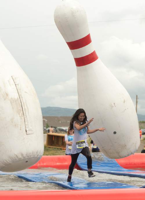 Rick Egan  |  The Salt Lake Tribune

Lauren Pak, 16, Sandy, tries to avoid the giant bowling pins as she runs the Jugglernaught obstacle in the 5K ThrillSeeker Stunt Run, which incorporates zip lines, the world's largest inflatable water slide, a Tarzan-like swing and punching walls, at Hee Haw Farms in Pleasant Grove, Saturday, May 23, 2015.