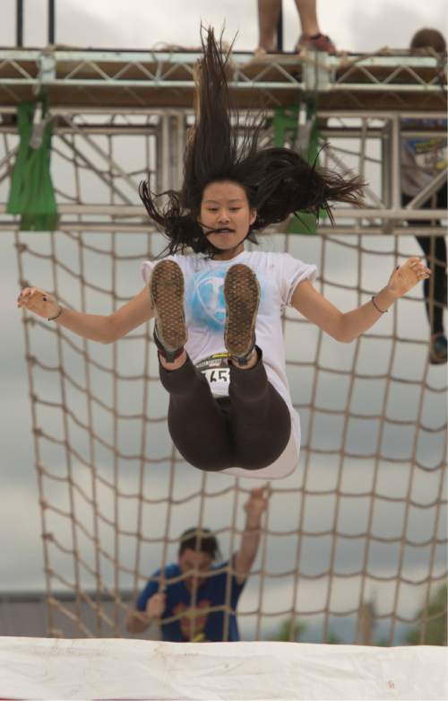 Rick Egan  |  The Salt Lake Tribune

Lauren Pak, 16, Sandy, lets go of the zip-line in the 5K ThrillSeeker Stunt Run, which incorporates zip lines, the world's largest inflatable water slide, a Tarzan-like swing and punching walls, at Hee Haw Farms in Pleasant Grove, Saturday, May 23, 2015.