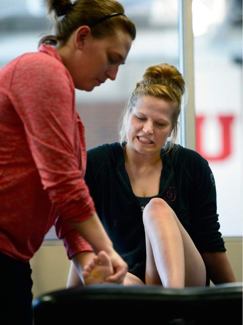 Scott Sommerdorf   |  The Salt Lake Tribune
Utah gymnast Tory Wilson grimaces as she rehabs her broken foot and torn achilles with Athletic Trainer Katie Lorens, left, in the training room adjacent to the Utah practice gym, Thursday, May 28, 2015. Lorens was stretching Wilson's right foot to increase the stretch in her foot with the achilles injury.