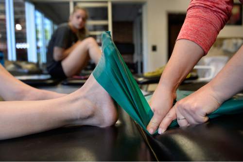 Scott Sommerdorf   |  The Salt Lake Tribune
Utah gymnast Tory Wilson stretches with a large band on her right foot with the achilles injury as she rehabs her broken foot and torn achilles with Athletic Trainer Katie Lorens in the training room adjacent to the Utah practice gym, Thursday, May 28, 2015.