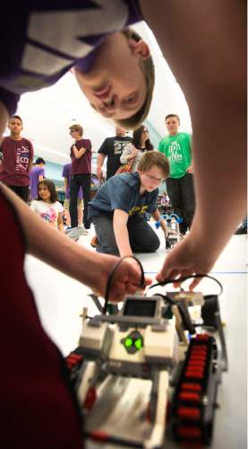 Steve Griffin  |  The Salt Lake Tribune
Cole McCleery, center, of West Jordan Middle School, ties a string around his robot as he prepares to do battle in the tug-o-war competition against Luke Campbell, of Oquirrh Hills Middle School, during the first ever Science, Technology, Engineering and Math (STEM) Showcase. More than 100 middle school students who have been involved in an after-school STEM program in Jordan School District were part of the fun. Computer programming students showed off their work as well. This special STEM program is funded by the STEM Action Center and Utah Department of Workforce Services. The battles took place at West Jordan High School in West Jordan, Wednesday, May 27, 2015.