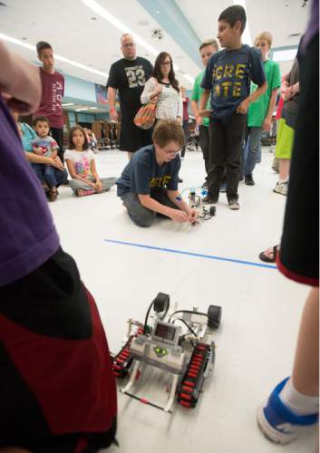 Steve Griffin  |  The Salt Lake Tribune
Cole McCleery, of West Jordan Middle School, ties a string around his robot as he prepares to do battle in the tug-o-war competition during the first ever Science, Technology, Engineering and Math (STEM) Showcase. More than 100 middle school students who have been involved in an after-school STEM program in Jordan School District were part of the fun. Computer programming students showed off their work as well. This special STEM program is funded by the STEM Action Center and Utah Department of Workforce Services. The battles took place at West Jordan High School in West Jordan, Wednesday, May 27, 2015.