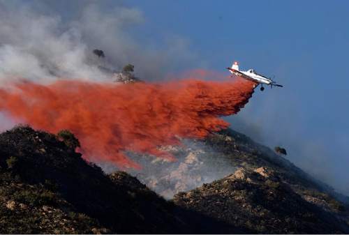 Djamila Grossman  |  The Salt Lake Tribune

A plane drops retardant on flames as a wildfire burns in the hills above the University of Utah Research Park in Salt Lake City, Utah, on Sunday, July 3, 2011.