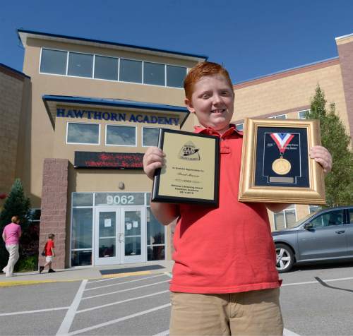 Al Hartmann |  The Salt Lake Tribune
Fifth-grader Brad Mason holds a plaque and medal at a crosswalk in front of Hawthorn Academy in West Jordan Monday June 2, 2015. He was given the highest award available to a AAA School Safety Patroller, the Lifesaving Medal. His awareness and quick-thinking actions while on duty as a patroller helped save the life of a little girl who was about to run out in front of traffic in front of the school.