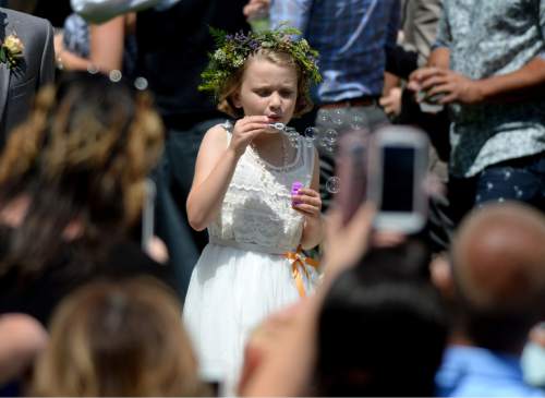 Steve Griffin  |  The Salt Lake Tribune
McKenzie Bogenschutz blows bubbles into the crowd as she walks down the aisle during Derek Kitchen and Moudi Sbeity's marriage ceremony at the Gallivan Center Plaza in Salt Lake City, Sunday, May 24, 2015.