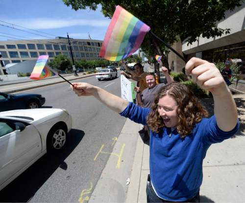 Al Hartmann  |  The Salt Lake Tribune 
Cappy Shapiro waves rainbow flag in a honk and wave in front of the Utah Pride Center in Salt Lake City Tuesday June 25 celebrating the 10th Circuit Courts ruling that states outlawing same-sex marriage are in violation of the U.S Constitution.