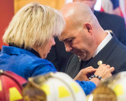 Rick Egan  |  The Salt Lake Tribune

Cindy Dale pins a pin on her husband, new Salt Lake City Fire Chief Brian Dale, at City Hall Thursday, June 4, 2015.