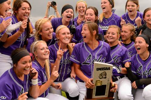 Trent Nelson  |  The Salt Lake Tribune
Lehi player celebrate after beating Herriman in the 5A high school softball championship game, in West Valley City, Friday May 22, 2015. Holding the trophy is Terra Tahbo.