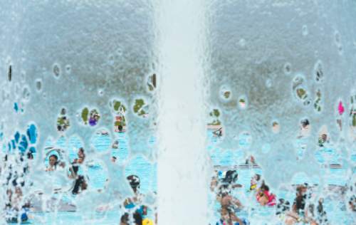 Steve Griffin  |  The Salt Lake Tribune

The Taylorsville Recreation Center swimming pool is seen through a waterfall Tuesday, June 9, 2015. Salt Lake County Health Department (SLCoHD) held its annual Healthy Swim Season media day to remind residents to practice healthy swimming behaviors and dispel a few pool myths.