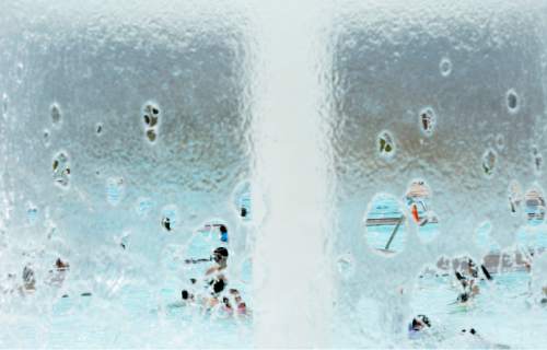 Steve Griffin  |  The Salt Lake Tribune

The Taylorsville Recreation Center swimming pool is seen through a waterfall Tuesday, June 9, 2015. Salt Lake County Health Department (SLCoHD) held its annual Healthy Swim Season media day to remind residents to practice healthy swimming behaviors and dispel a few pool myths.