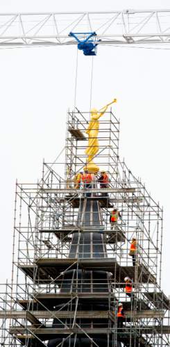 Steve Griffin  |   Tribune file photo
Construction crews work to attach the Angel Moroni statue after a crane lifted it to the top of the Provo City Center Temple in Provo in March 2014.