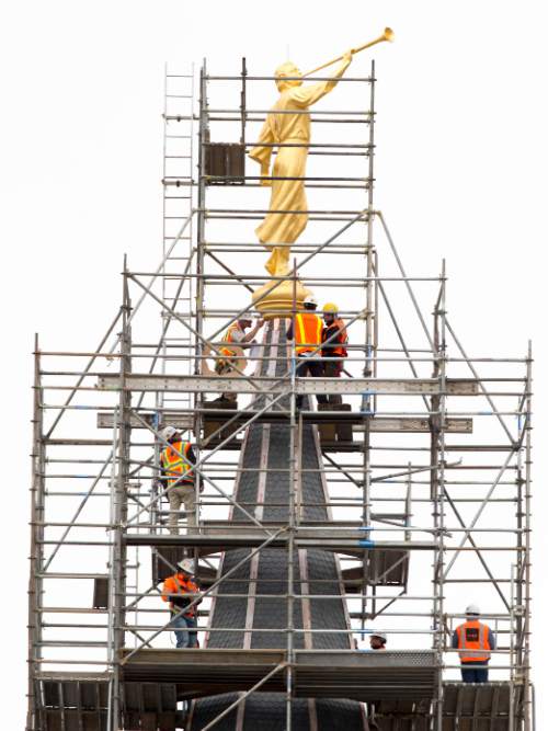 Steve Griffin  |  The Salt Lake Tribune

Construction crews work to attach the Angel Moroni statue after a crane lifted it to the top of the Provo City Center Temple in Provo, Utah Monday, March 31, 2014.