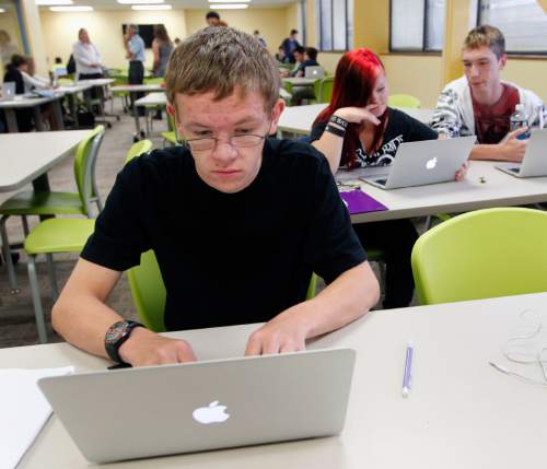 Al Hartmann  |  The Salt Lake Tribune
Brent Neville, a junior at Kaysville charter school Career Path High takes notes for a U.S History class while studying  a lesson from his laptop Tuesday September 10.  All 175 students were assigned an Apple laptop for the school year.