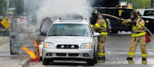 Steve Griffin  |  The Salt Lake Tribune
Salt Lake City Fire Department firefighters spray water on two cars that were burning on 900 South below the I-15 overpass in Salt Lake City on Thursday.