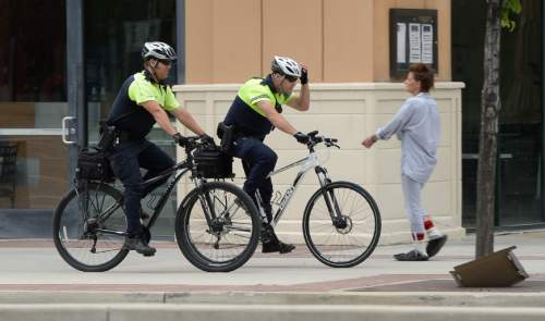 Francisco Kjolseth  |  The Salt Lake Tribune
Salt Lake City police officers Bryce Curdie, left, and Slade Bailey patrol the streets near The Gateway on Wednesday, June 10, 2015. The City Council will spend more money on bicycle cops in the first part of the coming fiscal year. The council has budgeted $1.1 million for eight bike patrol officers and eight social workers. The mayor's proposed $254 million budget starts July 1. The new bike patrols are expected in September.