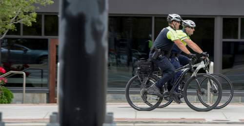 Francisco Kjolseth  |  The Salt Lake Tribune
Salt Lake City police officers Bryce Curdie, left, and Slade Bailey patrol the streets near The Gateway on Wednesday, June 10, 2015. The City Council will spend more money on bicycle cops in the first part of the coming fiscal year. The council has budgeted $1.1 million for eight bike patrol officers and eight social workers. The mayor's proposed $254 million budget starts July 1. The new bike patrols are expected in September.