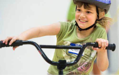 Steve Griffin  |  The Salt Lake Tribune


Ciera Troop, 8, is all smiles as she rides a bike by herself as forty people with special needs, ranging from age 7 to 35,  learn to ride bicycles for the first time at a camp being conducted this week at Summit Academy High School in Bluffdale, Thursday, June 11, 2015.  The camp is called Ride to New Heights, and the local sponsor is the non-profit, United Angels Foundation, which supports families and parents of children with special needs. They've brought in the national non-profit, I Can Shine that provide  instructors and special bikes that help those with disabilities learn to balance and, ultimately, ride on their own.
