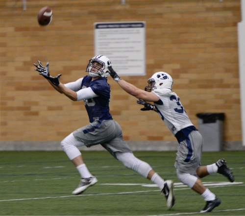 Francisco Kjolseth  |  The Salt Lake Tribune 
BYU football opens spring camp on Monday, March 2, 2015, with indoor practice at the Smith Fieldhouse as Josh Weeks reaches out for a pass with Eric Takenaka defending.