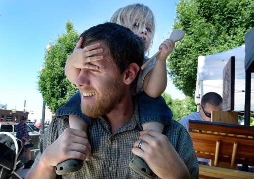 Scott Sommerdorf   |  The Salt Lake Tribune
Chris Blanc carries his two year old daughter Ada as best he can as she affects his vision during the first day of the Downtown Farmers Market's 2015 season on Saturday. Dozens of produce, food, arts and craft vendors will operate each Saturday from 8 a.m. to 2 p.m. through Oct. 24.