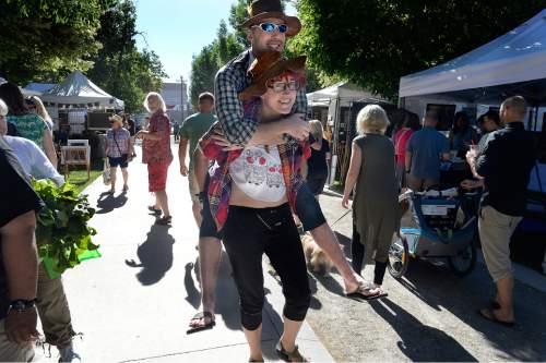 Scott Sommerdorf   |  The Salt Lake Tribune
Kira Sonntag carries her friend Jake Sparks, who has a broken foot, around the Downtown Farmers Market as it kicked off its season Saturday, June 13, 2015. Dozens of produce, food, arts and craft vendors will operate each Saturday from 8 a.m. to 2 p.m. through Oct. 24.