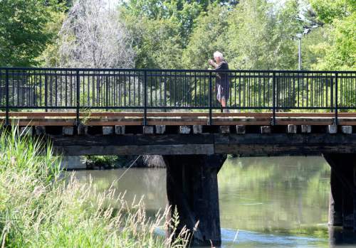 Al Hartmann  |  The Salt Lake Tribune
A man takes in the view from bridge over Jordan River near the restored wetlands at 1000 West and 900 South on June 17, 2015.  A recent survey of Salt Lake City residents about recreation and parks determined that open space parks and bike trails were important to people in the city.