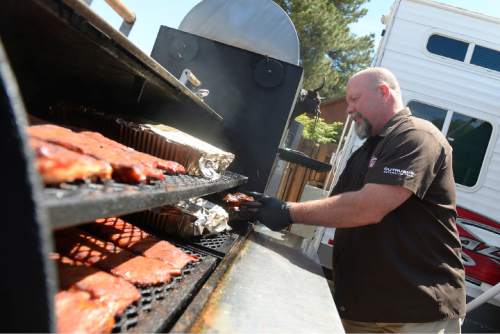 Leah Hogsten  |  The Salt Lake Tribune
Jesse Johnson pulls cuts of smoked and barbecued  brisket off the heat to cut and serve. Johnson is the event organizer of the barbecue contest and heads Great Western BBQ events. The 24th year of Real Men Can Cook, a fundraiser for the Your Community Connection Family Crisis Center in Ogden, Saturday, June 20, 2015, at Ogden Pioneer Stadium.