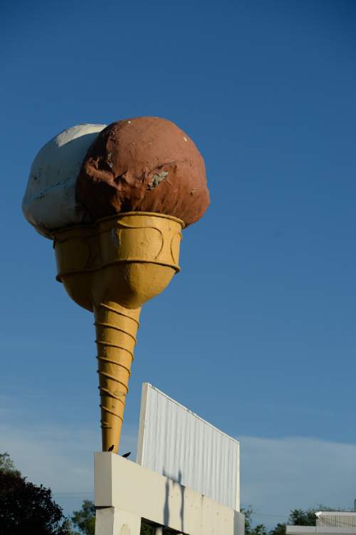 Francisco Kjolseth  |  The Salt Lake Tribune

The Snelgrove ice cream cone sits atop the sign that formerly marked the locally-owned ice cream shop on 2100 South. The original colors of the cone were brown and pink--chococlate strawberry. Here the cone sits atop the now Dreyer ice cream facility, who say they plan to refurbish the cone and get it spinning again.
