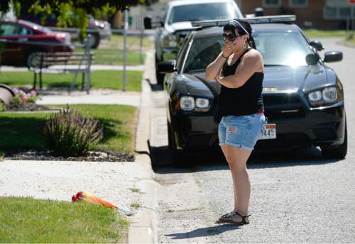 Francisco Kjolseth  |  The Salt Lake Tribune 
A woman grieves after placing flowers at a home next to Roy High school that was the scene of an apparent Father's Day murder-suicide carried out by the husband and father.