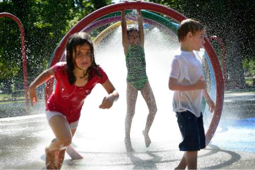 Scott Sommerdorf   |  The Salt Lake Tribune
Kids play at the splash pad water play area inside Liberty Park's Rotary Playground, Monday, June 29, 2015.