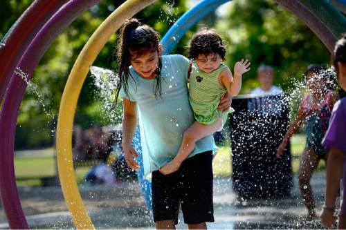 Scott Sommerdorf   |  The Salt Lake Tribune
Kids play at the splash pad water play area inside Liberty Park's Rotary Playground, Monday, June 29, 2015.