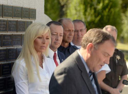Al Hartmann |  The Salt Lake Tribune
Nannette Wride, widow of slain Utah County Sheriff Sgt. Cory Wride listens as Gov. Gary Herberts speaks at police memorial outside the Utah Capitol before signing HB 288, which provides death benefits for Utah peace
officers and firefighters killed in the line of duty.  Rep. Paul Ray, the bill's sponsor and representatives of the law enforcement and fire fighter community stand with her.