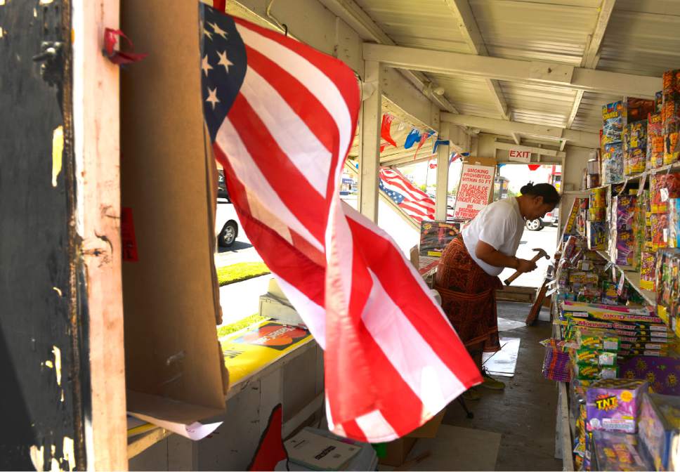 Leah Hogsten  |  The Salt Lake Tribune
Saumalu Gasu nails price tags into place during the first few hours of operation at the TNT Fireworks stand at 2700 S. State. Fireworks went on sale Wednesday, July 1, 2015.