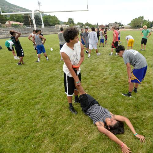 Al Hartmann |  The Salt Lake Tribune
Next season's prospective Ogden High School football team players rest and work out muscle cramps during a summer conditioning workout Thursday June 11, 2015. The team belongs in Class 4A purely by enrollment numbers, but the football program argued during recent UHSAA realignment meetings that, based on a historic lack of competitiveness, it should be dropped down a classification or two to allow the program to rebuild.