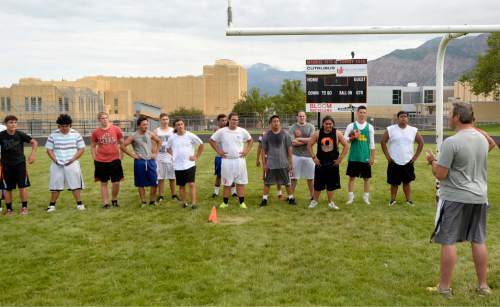 Al Hartmann |  The Salt Lake Tribune
Ogden High School football coach Kent Taylor, right, encourages his players during a summer conditioning workout Thursday June 11, 2015. The team belongs in Class 4A purely by enrollment numbers, but the football program argued during recent UHSAA realignment meetings that, based on a historic lack of competitiveness, it should be dropped down a classification or two to allow the program to rebuild.