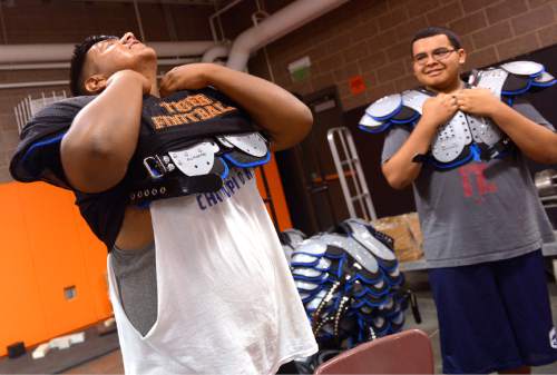 Leah Hogsten  |  The Salt Lake Tribune
l-r As sophomore Fabian Cabrera struggles to take off his shoulder pads, his teammate Martino Diaz giggles at his misfortune. After last season's struggle, Ogden High School's football program decided to play an independent schedule for the next two years.