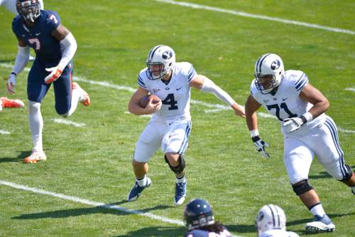 Chris Detrick  |  The Salt Lake Tribune
Brigham Young Cougars quarterback Taysom Hill (4) runs the ball during the game at LaVell Edwards Stadium Saturday September 20, 2014.  Virginia is winning the game 16-13 at halftime.