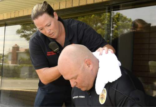 Rick Egan  |  The Salt Lake Tribune

West Valley Paramedic, Mary Lindsay-Vonk takes cools down Police Officer, Dana Pugmire's after he sat in his car for 15 minutes in the heat of the day, during a press conference to illustrate the dangers of leaving children and pets in hot cars, Thursday, July 2, 2015.