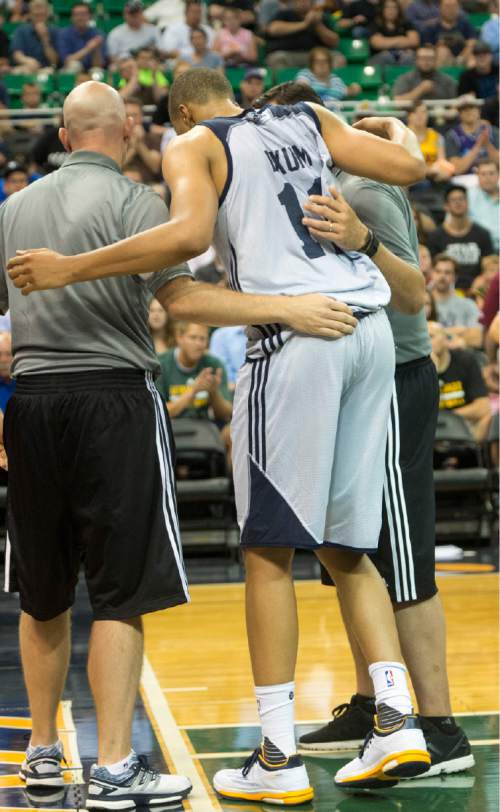 Rick Egan  |  The Salt Lake Tribune

Utah Jazz guard Dante Exum (11) is helped off of the floor after injuring his ankle, late in the game, in Utah Jazz Summer League action, Utah Jazz vs. The Boston Celtics, at EnergySolutions Arena, Monday, July 6, 2015.