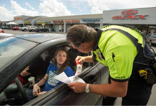 Rick Egan  |  The Salt Lake Tribune

West Valley police officer Kim Albrecht gives a written warning Rob Lovato, 18, for not wearing a seat belt, on Redwood Road in West Valley City, Thursday, May 28, 2015.