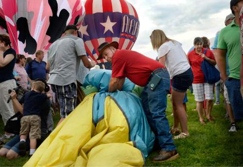 Scott Sommerdorf   |  The Salt Lake Tribune
Dominic Chemello packs up his balloon named "The Don" after the decision was made not to launch due to changeable weather at the Provo Balloon Fest, Saturday, July 4, 2015.