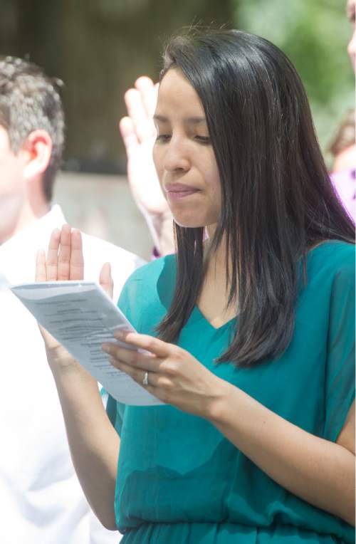 Rick Egan  |  The Salt Lake Tribune

Katea Jazminne Spencer holds up her right hand as she is sworn in as a new United States citizen, during a ceremony at Scera Park, in Orem, Friday, July 3, 2015.