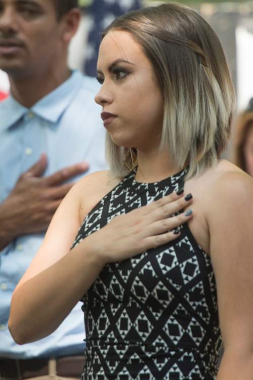 Rick Egan  |  The Salt Lake Tribune


Andrea Castaneda, originally from Argentina,  puts her hand on her heart as she listens to the national anthem, before being sworn in as a new citizen of the United States, during a ceremony at Scera Park, in Orem, Friday, July 3, 2015.