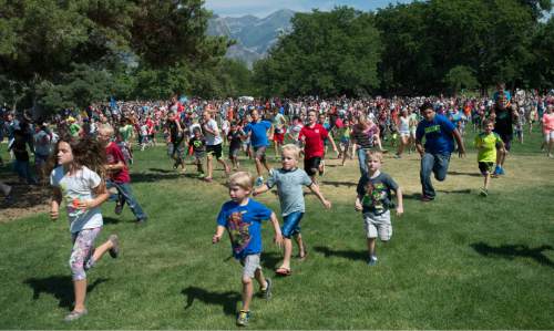 Rick Egan  |  The Salt Lake Tribune

Thousands of kids run to grab the 1000 candy bars from a fixed wing bomber from World War II piloted by former Air Force Col Gal Halvorsen, at Scera Park, in Orem, Friday, July 3, 2015.